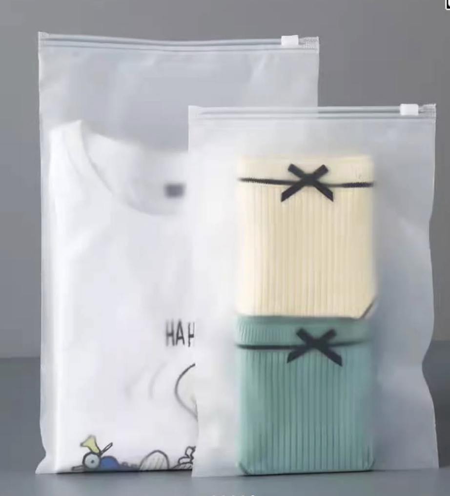 Two pairs of socks in clear plastic bags with visible branding on a gray background