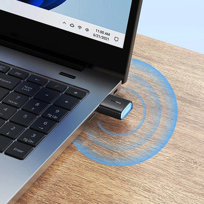 USB adapter connected to a laptop on a wooden surface