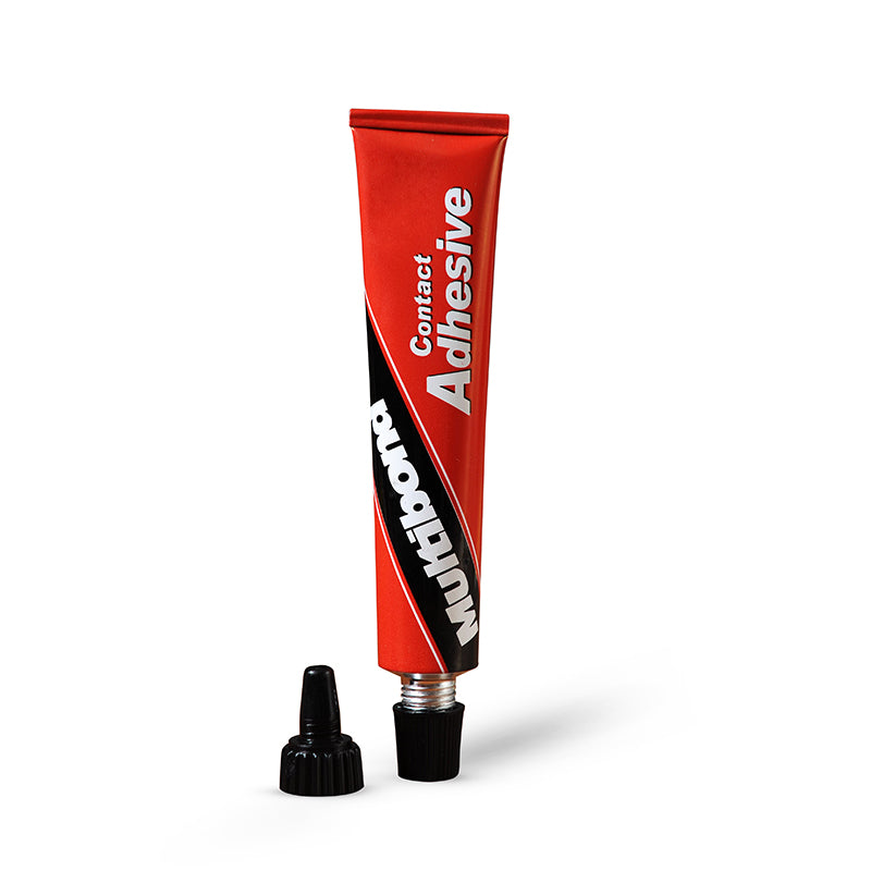 Red tube of contact adhesive with black cap on a white background