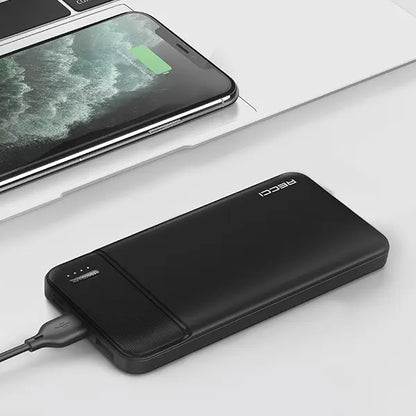 Black power bank connected to a smartphone on a white surface