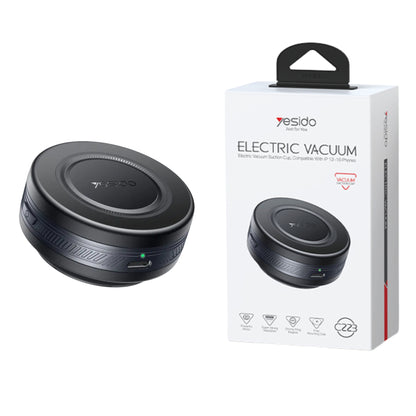 Black electric vacuum cleaner next to its packaging on a white background